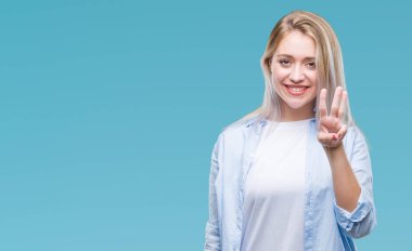 Sarışın genç kadın gösterilen ve parmakları ile işaret izole arka plan üzerinde üçüncü ise kendinden emin ve mutlu gülümseyerek.