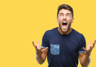 Genç yakışıklı adam izole arka plan çılgın ve kızgın bağırarak ve agresif ifade ve silah kaldırdı bağırıyor. Hayal kırıklığı kavramı.