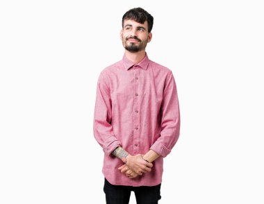 Yakışıklı delikanlı görünümlü yan ve dik dik bakma uzağa düşünce gülümseyen izole arka plan üzerinde pembe gömlek giymiş.