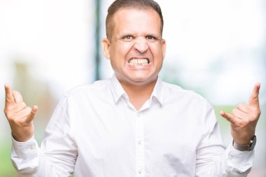 Orta yaş Arap zarif adam deli ifade rock simge elle yapıyor ile bağırarak izole arka plan. Müzik yıldızı. Ağır kavramı.