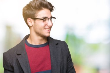 Uzak tarafına yüzünde, doğal ifade gülümseme ile seyir izole arka plan üzerinde gözlük takan genç yakışıklı zarif adam. Kendine güvenen gülüyor.