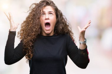 Rahat giyen güzel genç esmer kıvırcık saçlı kız bak deli kutluyor izole arka plan üzerinde ve crazy arms ile başarı için kaldırdı ve heyecanlı çığlık gözler kapalı. Kazanan kavramı