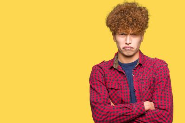 Yüz çapraz kolları olan bir ceket şüpheci ve sinir, onaylamayan ifade giyen afro saçlı Genç yakışıklı öğrenci adam. Negatif kişi.