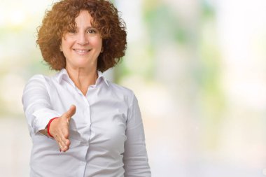 Güzel orta ager üst düzey businees kadın dostu sunan el sıkışma tebrik ve davet edici olarak gülümseyen izole arka plan yüzünden. Başarılı iş.