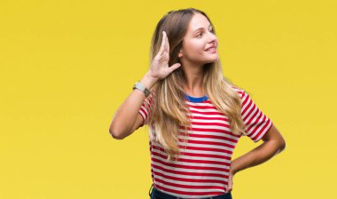 Genç güzel sarışın kadın bir işitme söylenti ya da dedikodu için dinleme kulak üzerinde el ile gülümseyen izole arka plan yüzünden. Sağırlık kavramı.