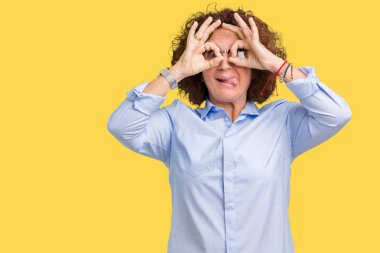 Güzel orta ager üst düzey businees kadın dilini, parmaklarının arasından baktığını yapışmasını dürbün gibi ok jest yapıyor izole arka plan üzerinde gözlük takıyorum. Deli ifade.