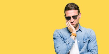 Seyir düşünüyorum yakışıklı adam giyen moda güneş gözlüğü yorgun ve sıkılmış çapraz silah depresyon sorunları ile.