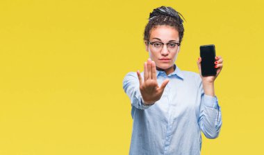 Genç saç Afro-Amerikan iş kız gösteren ekran smartphone izole arka plan üzerinde açık eliyle dur işareti ile ciddi ve kendine güvenen ifade, savunma jest yapıyor örgülü