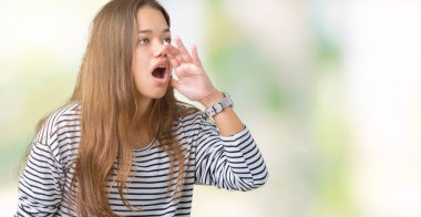 Bağırarak ve ağzı üzerinde el ile yan için çığlık izole arka plan üzerinde çizgili süveter giyen genç güzel esmer kadın. İletişim kavramı.