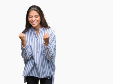 Gülümseyen ve başarı için çığlık genç güzel Arap kadın izole arka plan çok mutlu ve heyecanlı kaldırdı, silah ile kazanan jest yapıyor. Kutlama kavramı.