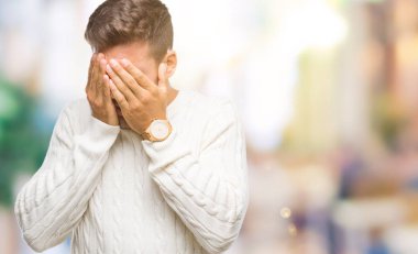 Genç yakışıklı adam üzgün ifade yüz eller ile ağlayarak süre kapsayan ile izole arka plan üzerinde kış kazak giyiyor. Depresyon kavramı.