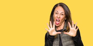 Kış yelek korkuyor ve korku ifade dur hareketi el ile ile dehşete giyen güzel orta yaş kadın şok bağırarak. Panik kavramı.