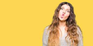 Genç güzel kadın giyiyor kış giysi yapma balık yüz dudaklı, çılgın ve komik bir jest. Komik ifade.