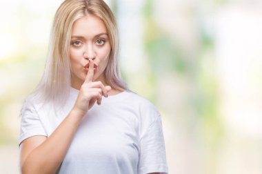 Genç Sarışın kadın dudaklarında parmak ile sessiz olmanı izole arka plan yüzünden. Sessizlik ve gizli kavramı.