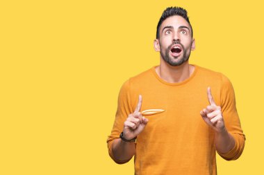 Yakışıklı delikanlı izole arka plan üzerinden hayran ve yukarıya bakıp parmakları ile işaret şaşırttı ve silah kaldırdı.