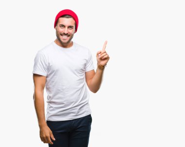 Kameraya bakarak yan el ve parmak ile işaret eden genç yakışıklı adam yüzünde kocaman bir gülümseme ile izole arka plan üzerinde.