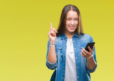 Genç güzel beyaz kadın mesaj Gönderen mesaj üzerinde Smartphone kullanarak arka plan ile bir fikir ya da gülen yüz, bir numara ile parmak işaret soru sürpriz izole