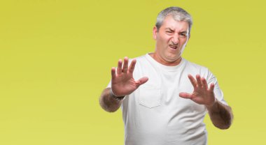 Şokta bağırarak yakışıklı üst düzey adam izole arka plan korkuyor ve korku ifade dur hareketi el ile ile çok korkmuş. Panik kavramı.