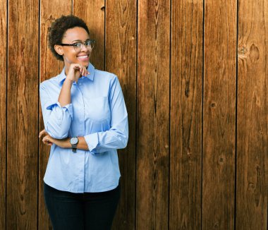 Genç güzel Afro-Amerikan iş kadın izole arka plan emin çapraz kollar ve çeneme kaldırdı el ile gülümseme ile kameraya bakıyor. Pozitif düşünce.