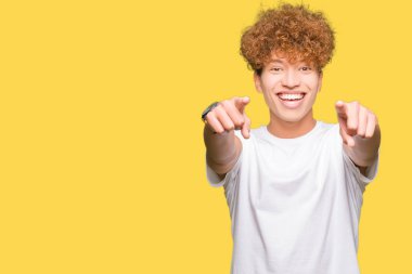 Olumlu ve neşeli gülümseyen casual beyaz t-shirt işaretleme ve parmaklar, kamerayla giyen afro saçlı Genç yakışıklı adam