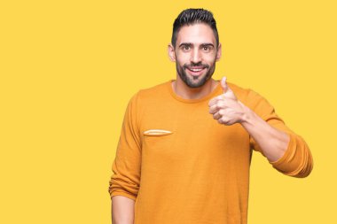 Yakışıklı delikanlı hareketi el ile mutlu yaşasın yapıyor izole arka plan üzerinde. Başarı gösteren kameraya bakarak ifade onaylama.