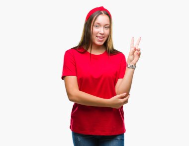 Mutlu yüz zafer işareti yaparken kameraya göz kırpıyor ile gülümseyen izole arka plan üzerinde genç Kafkas güzel kadın. İki numaralı.