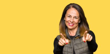 Sen ve kamera güzel orta yaş kadın giyiyor kış yelek işaretleme olumlu ve neşeli gülümseyen parmakları ile