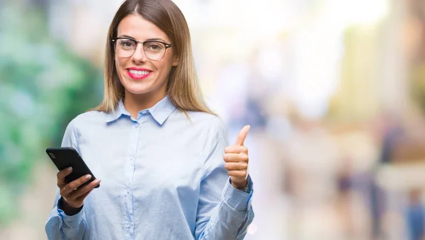 年轻美丽的商业妇女短信信息使用智能手机在孤立的背景快乐与大微笑做 拇指与手指 优秀的标志 — 图库照片