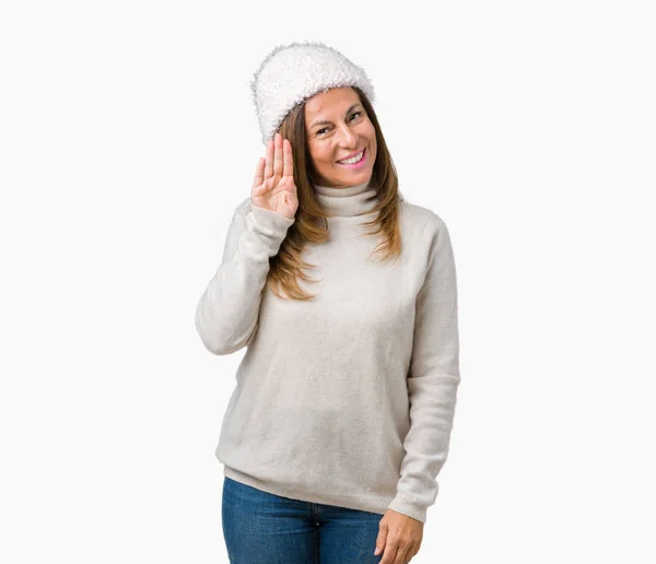 笑顔でフレンドリーな歓迎の意思表示と分離背景 Waiving あいさつ幸せに帽子冬のセーターを身に着けている美しい中年女性 — ストック写真