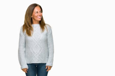 Üzerinde kış kazak giyen güzel orta yaş yetişkin kadın arka plan uzak tarafına gülümseme ile yüzünde, doğal ifade arıyorum izole. Kendine güvenen gülüyor.