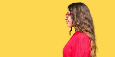 Tarafına, seyir kırmızı gözlük takan genç güzel kadın dinlenmek doğal yüz emin gülümseme ile pozuyla profili.