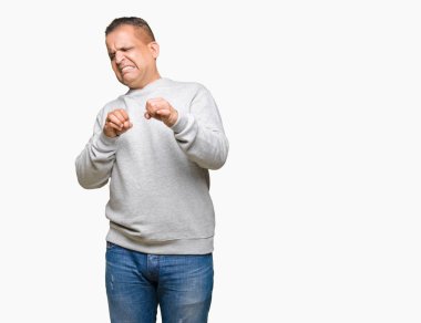 İzole arka plan üzerinde spor kazak giyen orta yaş Arap adam tiksinti ifadesi, memnun ve korkulu tiksinti yüz yapıyorsun çünkü nefret tepki. Elleriyle kaldırdı. Sinir bozucu kavramı.