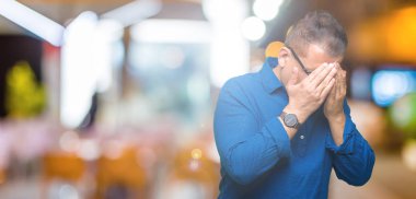 Orta yaş Arap adam gözlüklü izole arka plan üzerinde üzgün ifadeyle yüz eller ile ağlayarak süre kapsayan. Depresyon kavramı.