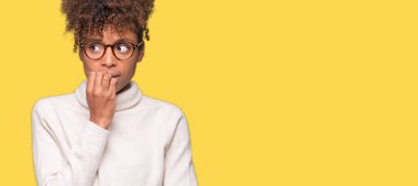 Stresli ve gergin elle çivi ısırma ağzına bakarak izole arka plan üzerinde gözlük güzel genç Afro-Amerikan kadın. Anksiyete sorunu.