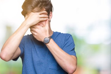 Yakışıklı delikanlı izole arka plan kaplaması gözler ve ağız el ile üzerinden mavi t-shirt giyen şaşırttı ve şok. Duygu gizleme