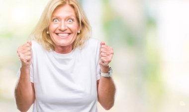 Orta yaş sarışın kadın izole arka kolları olan başarı için heyecan üzerinde zafer kutluyor gülümseyen kaldırdı. Kazanan kavramı.