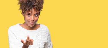 Güzel genç Afro-Amerikan kadın giyiyor kış kazak Beckoning gel burada mutlu ve gülümseyerek el davet ile jest izole arka plan üzerinde