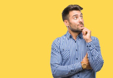 Yakışıklı delikanlı çene düşünme hakkında soru, dalgın ifade üzerine el ile izole arka plan üzerinde. Düşünceli yüzüyle gülümsüyor. Şüphe kavramı.