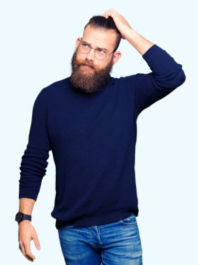 Genç sarışın adam gözlük ve balıkçı yaka kazak yanıltır ve soru hakkında merak ediyorum. Şüphe, kafasına el ile düşünme ile belirsiz. Dalgın kavramı.