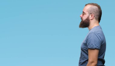 Genç beyaz hipster adam giyen güneş gözlüğü izole arka tarafına, seyir üzerinde dinlenmek doğal yüz emin gülümseme ile pozuyla profili.