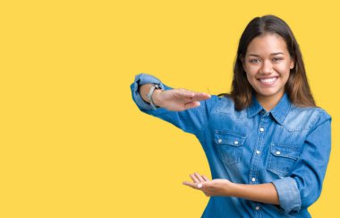 İzole arka plan eller eller büyük gösterilen ve büyük boy işareti, ölçü birimi sembolü ile üzerinde mavi kot gömlek giyen genç güzel esmer kadın. Kameraya bakarak gülümsüyordu. Ölçüm kavramı.