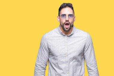 Yakışıklı delikanlı korkuyor ve şok sürpriz ifade, korku ve heyecan yüz ile izole arka plan üzerinde güneş gözlüğü takıyor.