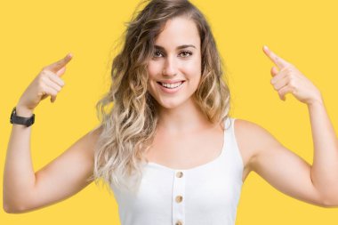 Güzel genç sarışın kadın izole arka plan üzerinde her ikisi ile baş gösteren gülen eller parmak, harika bir fikir ya da düşünce, iyi hafıza