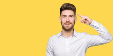 Genç yakışıklı iş bir parmak, harika bir fikir ya da düşünce, iyi hafıza ile baş gösteren gülen adam