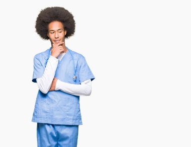 Çene düşünme hakkında soru, dalgın ifade üzerine el ile afro saçlı genç Afro-Amerikan Doktor adam. Düşünceli yüzüyle gülümsüyor. Şüphe kavramı.