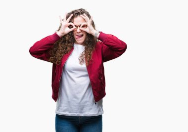 Güzel esmer kıvırcık saçlı Genç kız, dilini parmaklarının arasından baktığını yapışmasını dürbün gibi ok jest yapıyor izole arka plan üzerinde ceket ve gözlük takıyor. Deli ifade.