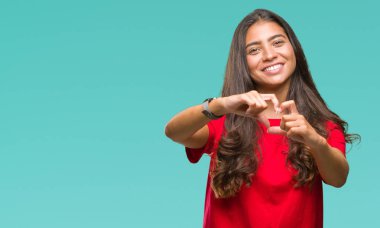 Genç güzel Arap kadın kalp simgesi ve elleriyle şekil gösterilen aşık gülümseyen izole arka plan yüzünden. Romantik kavramı.