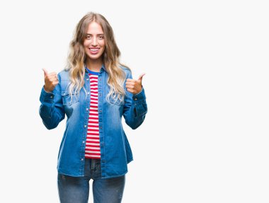 İzole arka plan başarı işareti el ile pozitif jest yapıyor güzel genç sarışın kadın başparmak gülümseyen ve mutlu. Neşeli bir ifadeyle, kazanan jest kameraya bakıyor.