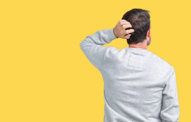 Yakışıklı orta yaş komuta sizde izole arka plan geriye düşünme hakkında şüphe kafasına el ile üzerinden bir kazak giyiyor