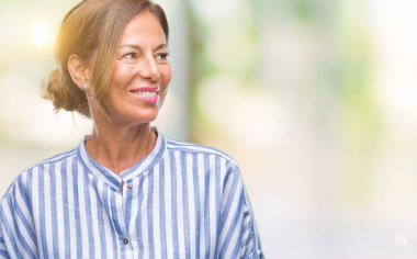 İzole arka plan uzak tarafına gülümseme ile yüzünde, doğal ifade seyir üzerinde orta yaş İspanyol kadın kıdemli. Kendine güvenen gülüyor.